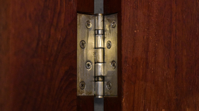 Door hinge on dark wood