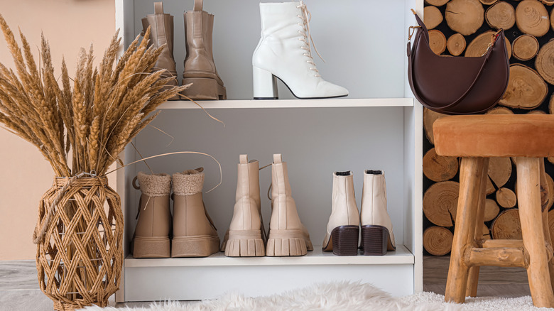 Multiple pairs of boots stored on low bookshelf