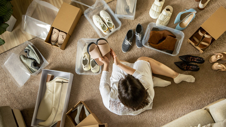 Birds eye view of woman packing away pairs of shoes into boxes