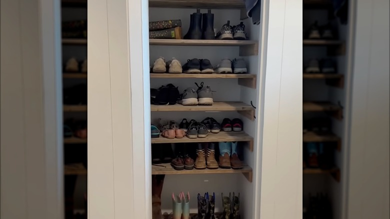 Shoes on racks in an entryway closet
