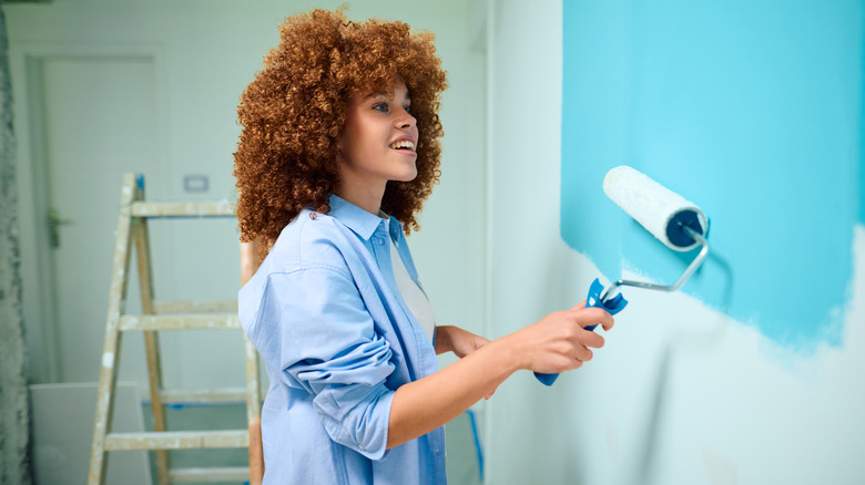 Woman painting home walls blue