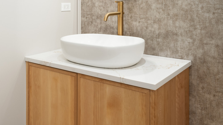 Honey oak cabinets with gold faucet