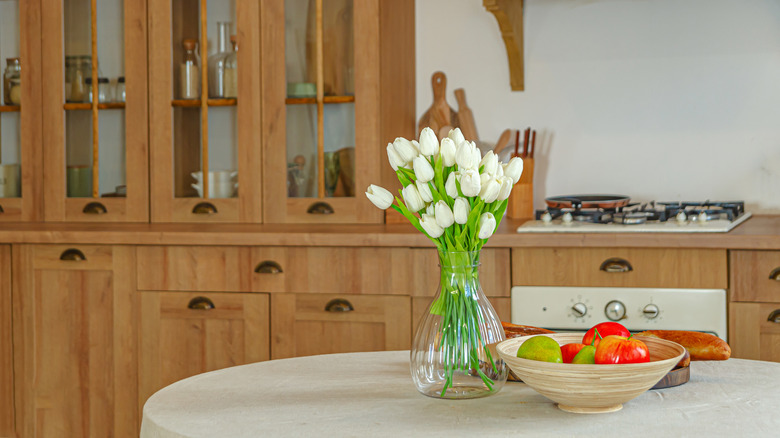 Honey oak cabinets in kitchen with off-white walls