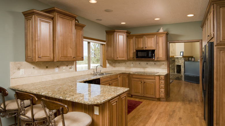 Kitchen with sage walls and honey oak cabinets