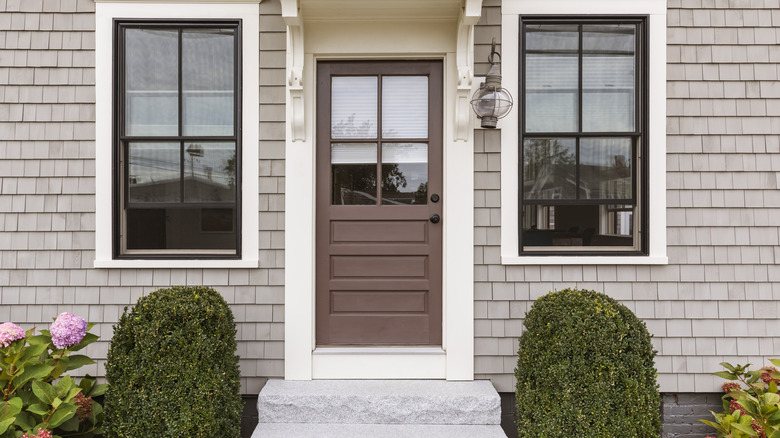 Clapboard cottage with medium matte brown door