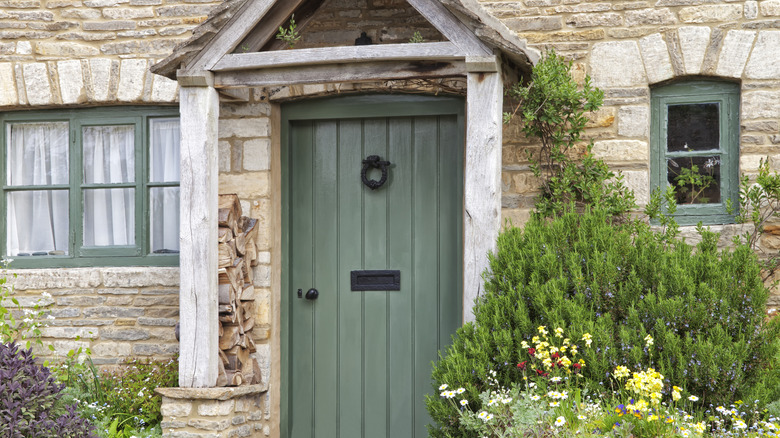 Sage green front door on a limestone house