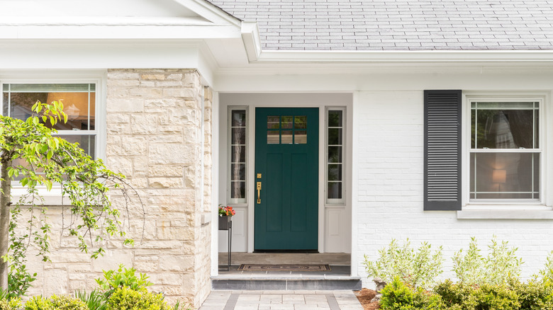 Blue-green front door on a whitewashed brick home