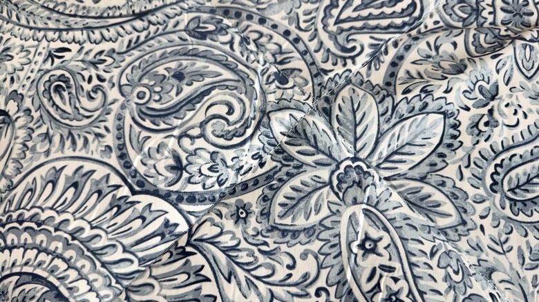 A close uup of a blue and white tribal print comforter.
