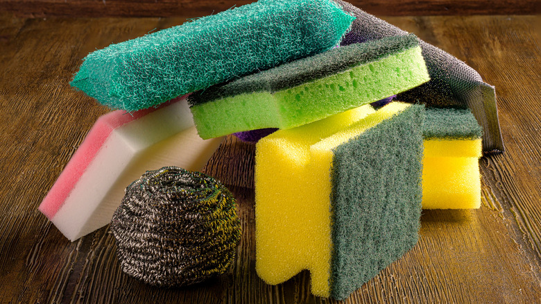 Pile of abrasive sponges and steel wool on wooden surface