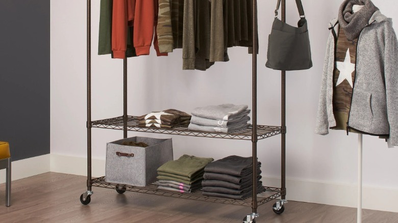 Costco clothing garment rack with hanging rail and folded clothes on the two bottom shelves