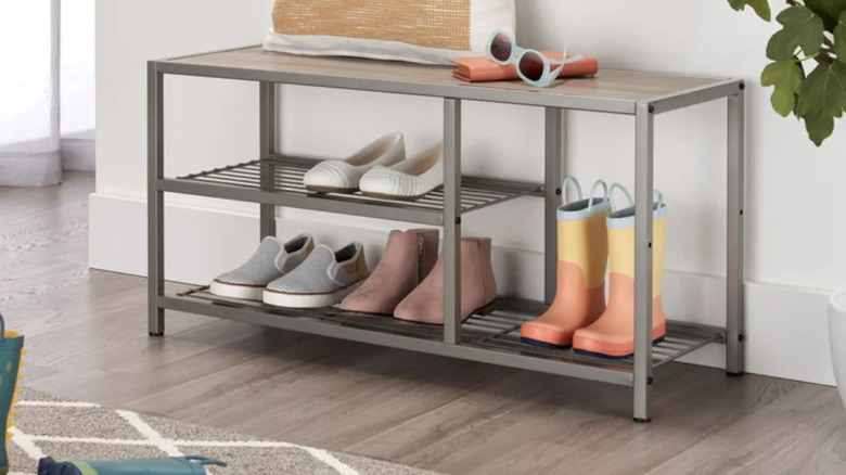 Costco shoe storage bench with various pairs of shoes and boots in the foyer of a home