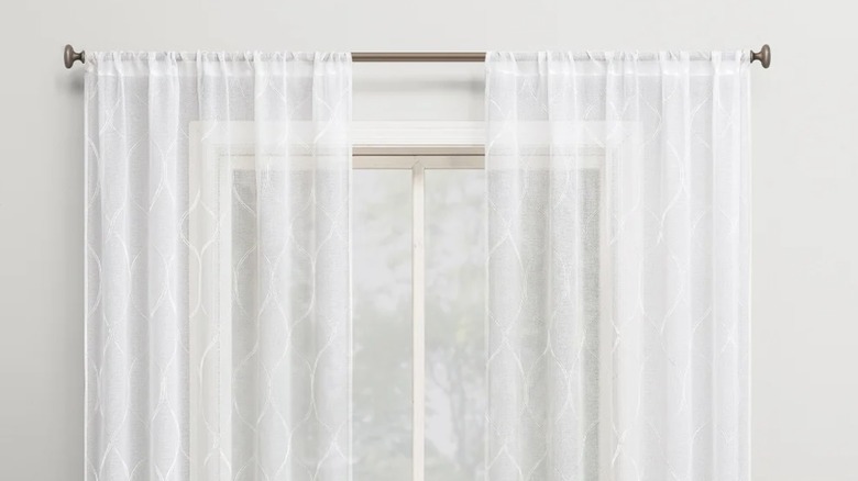 Portside embroidered trellis sheer curtains over a window against a gray wall
