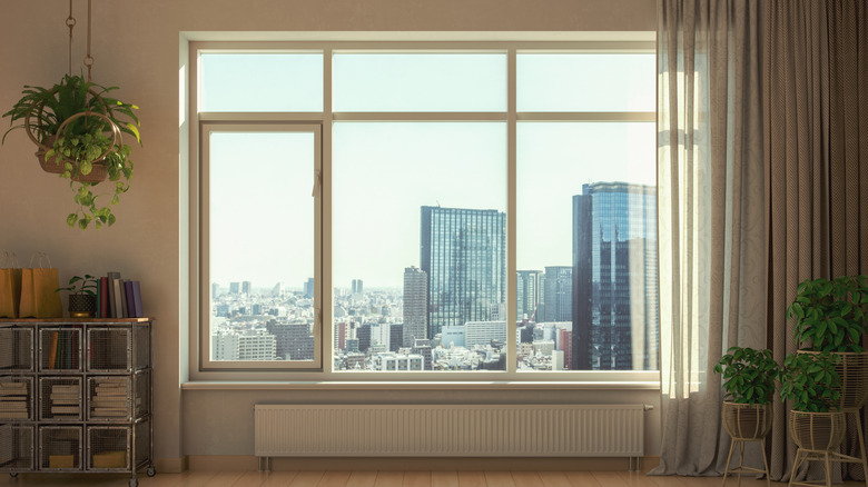 large window with curtains looking at cityscape