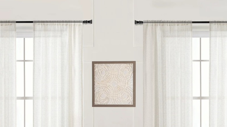 Taylor & Moxie's sheer linen blend curtain across two windows with a framed picture between them