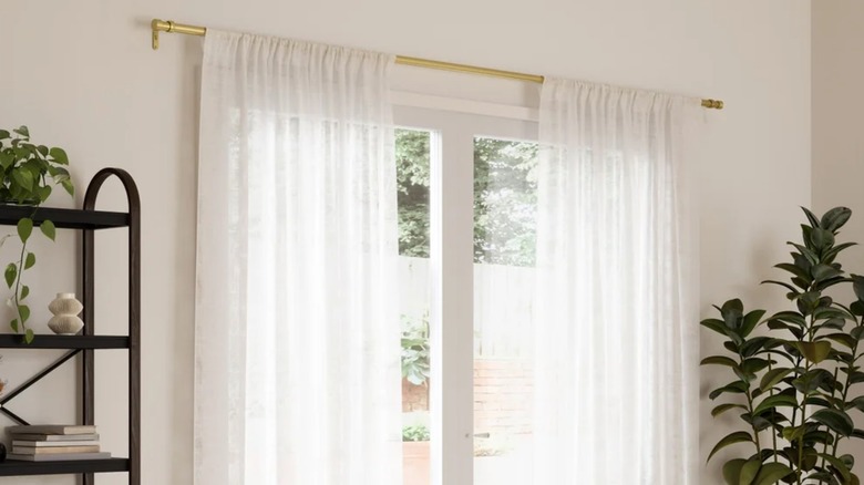 Umbria curtain rod in brass over a sliding glass door