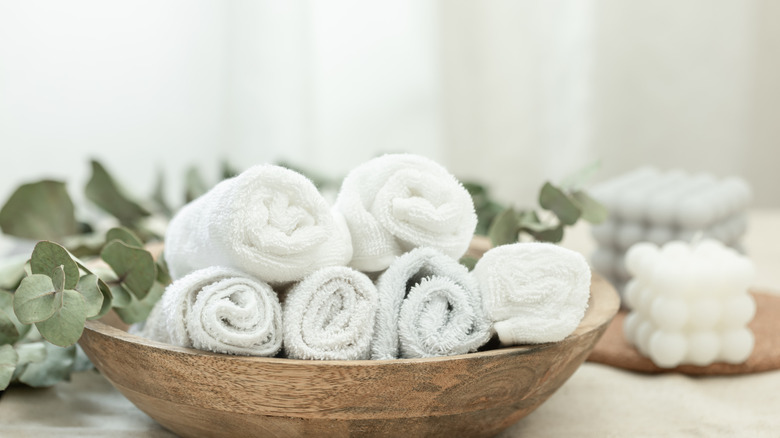 Close up of rolled towels in wooden bowl