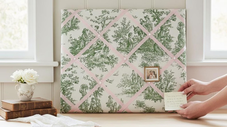 A fabric toile floral padded notice bulletin board.
