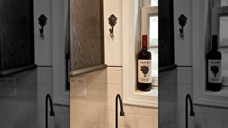 Rings hang on an elegant curtain tie back above the sink next to a window