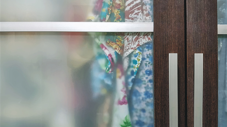 Wooden wardrobe with translucent glass doors.