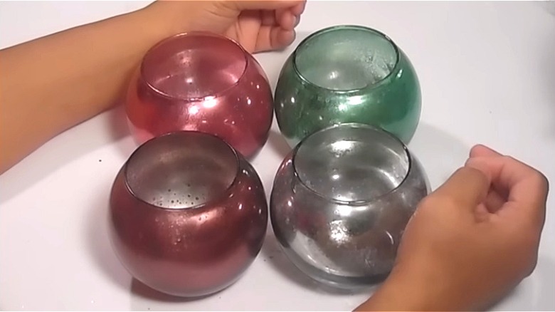 Person gathering colorful mercury glass candle holders