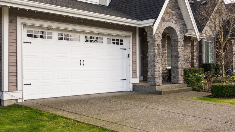Stone facade house with garage and a rectangular driveway