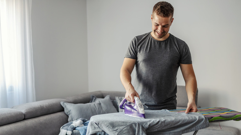 man ironing clothes