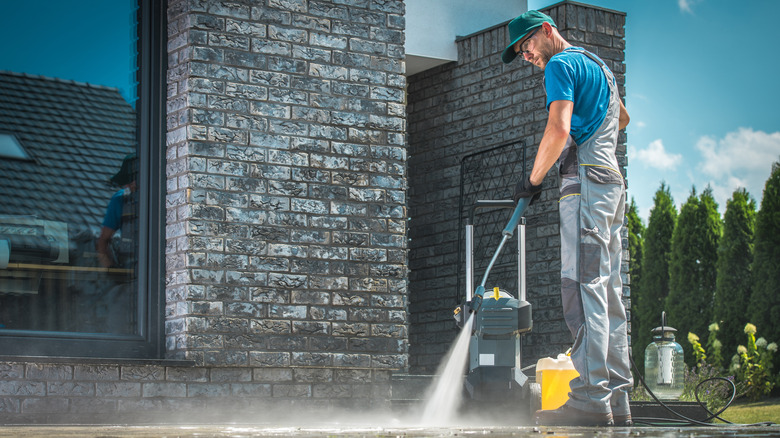 Man pressure-washing concrete