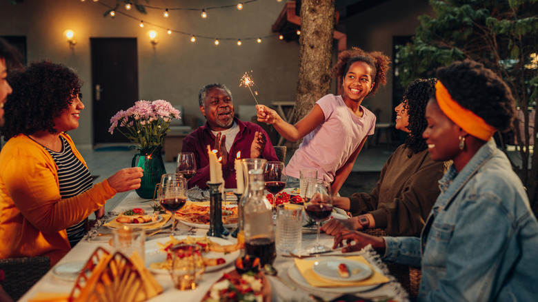 family eating dinner in backyard