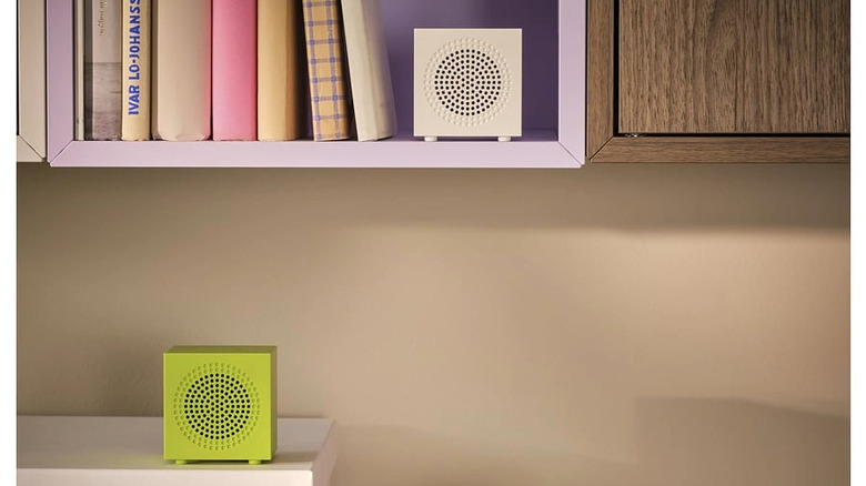 Small portable Bluetooth speakers sitting on bookshelves