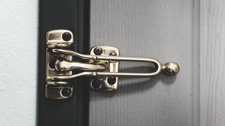 A front door fitted with a reinforcement lock with the latch closed.