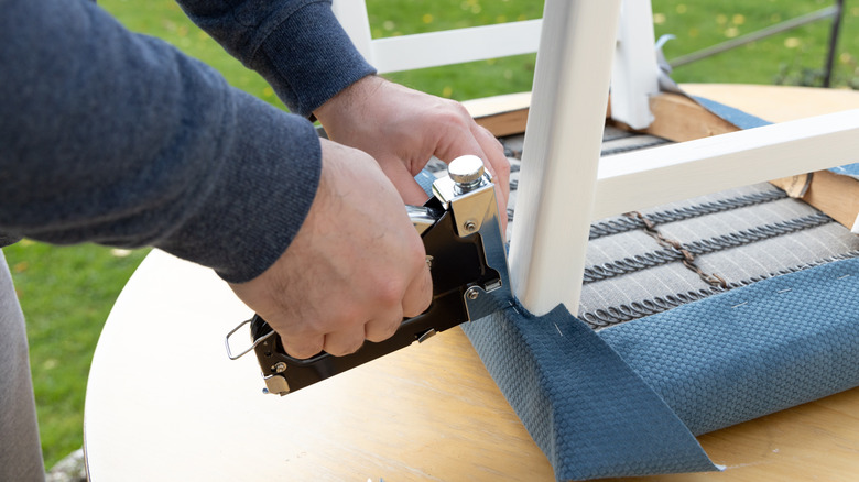 A man reupholstering a chair.