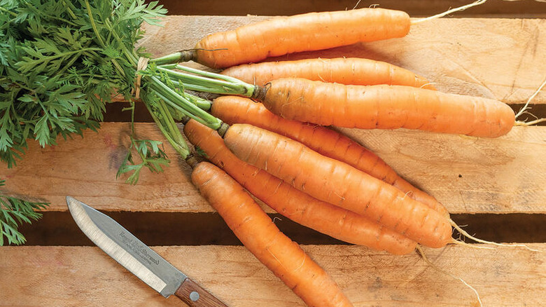 'Adelaide' carrots on wood next to a knife