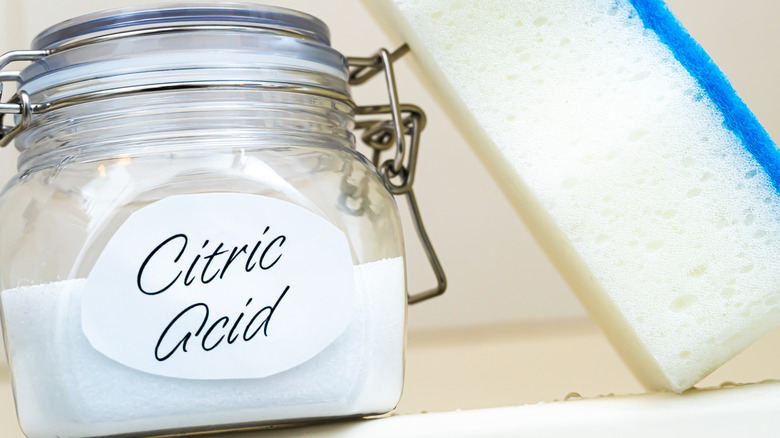 Citric acid powder in a glass jar with a sponge