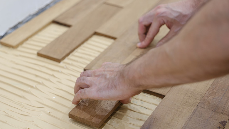 man installing parquet wood floor