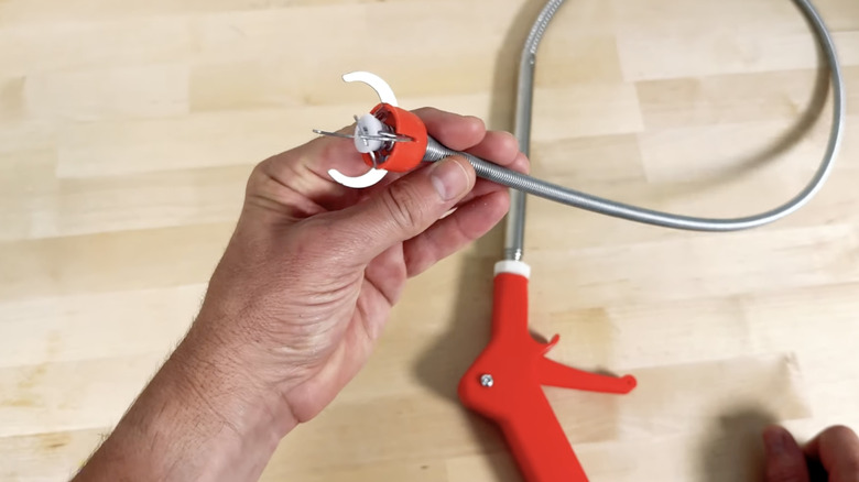 A claw pick-up tool used to unclog drains.