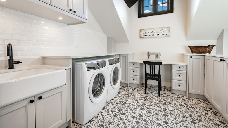 A patterned linoleum floor in a large laundry room with a sink and desk