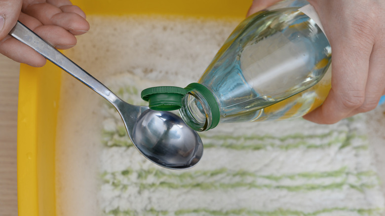 Vingear being added to a bucket to make a cleaning solution