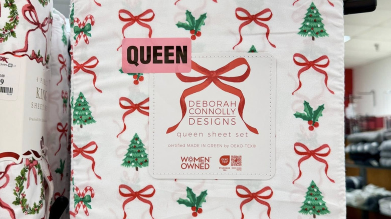 Queen-sized Christmas bed sheets from TJ Maxx with mistletoe, ribbons, and Christmas trees still in their packaging