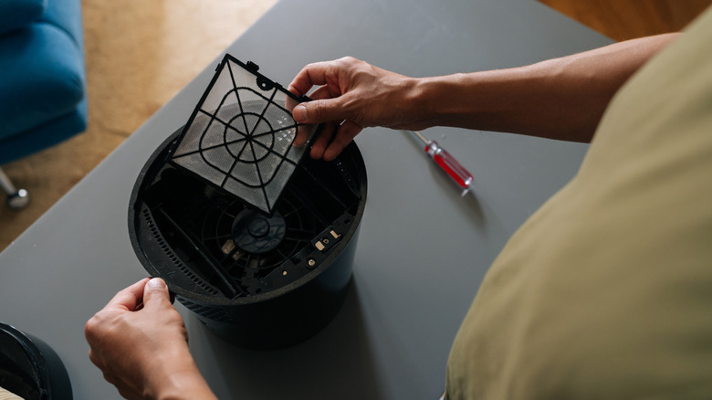 A person removing the filter from a humidifier