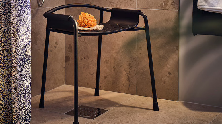 Black contemporary shower chair in corner of large format tile shower