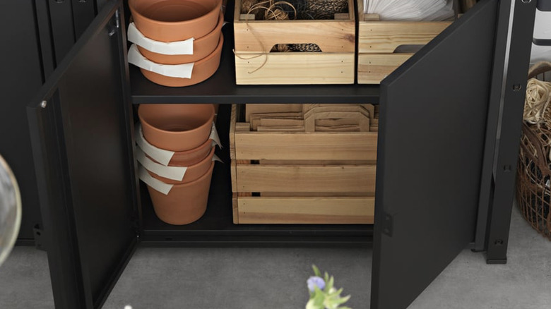 IKEA BROR cabinet holding plant pots and wood bins