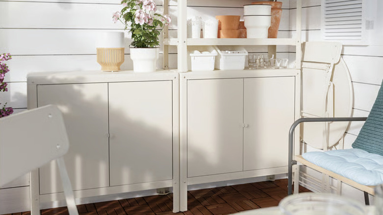 IKEA KOLBJÖRN Cabinet on a patio with plants and plant supplies on shelves.