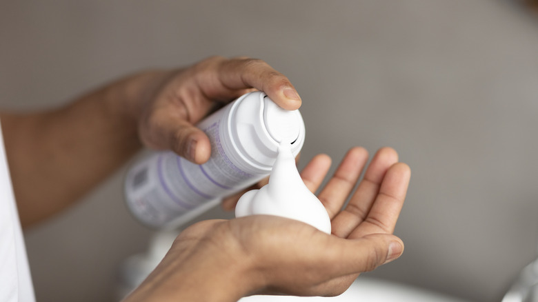 Man squirting shaving foam into his hand