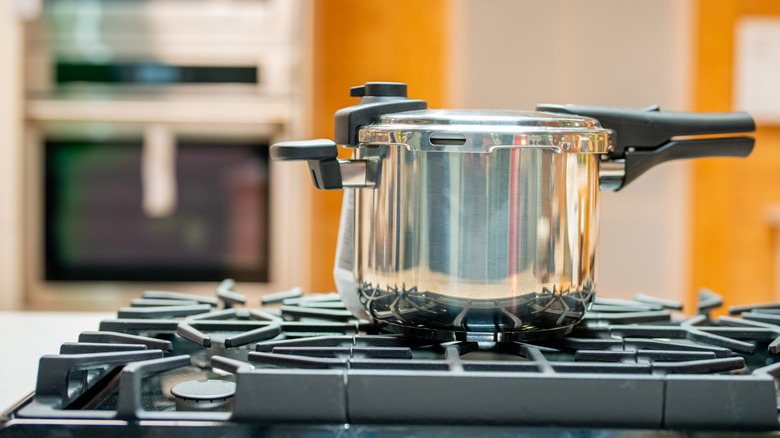 A stainless steel pressure cooker on a stove.