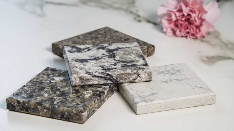 countertop samples sitting on marble surface with flower in background