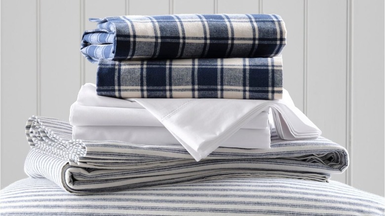 Stack of LL Bean Ultrasoft Comfort Flannel Sheet Sets against a white beadboard wall