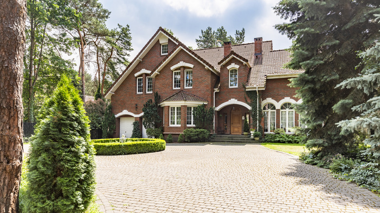 Large brick house with landscaping and paver driveway