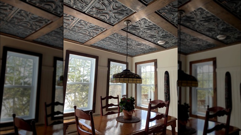 Tin ceiling tiles with wood beam accents in a vintage modern dining room