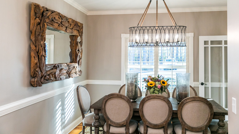 Dining room with a mirror on the wall directly in line with the table