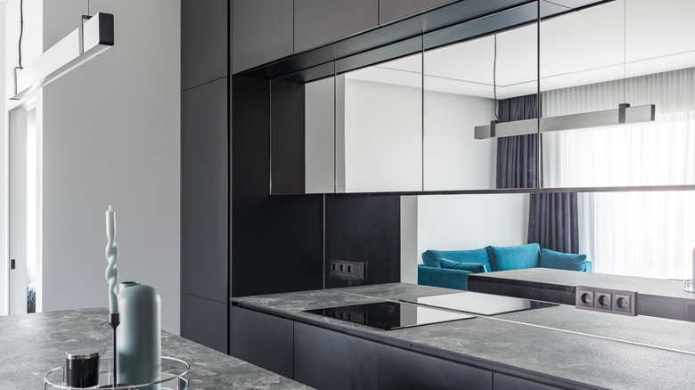 A modern kitchen with mirrored cabinets and backsplash